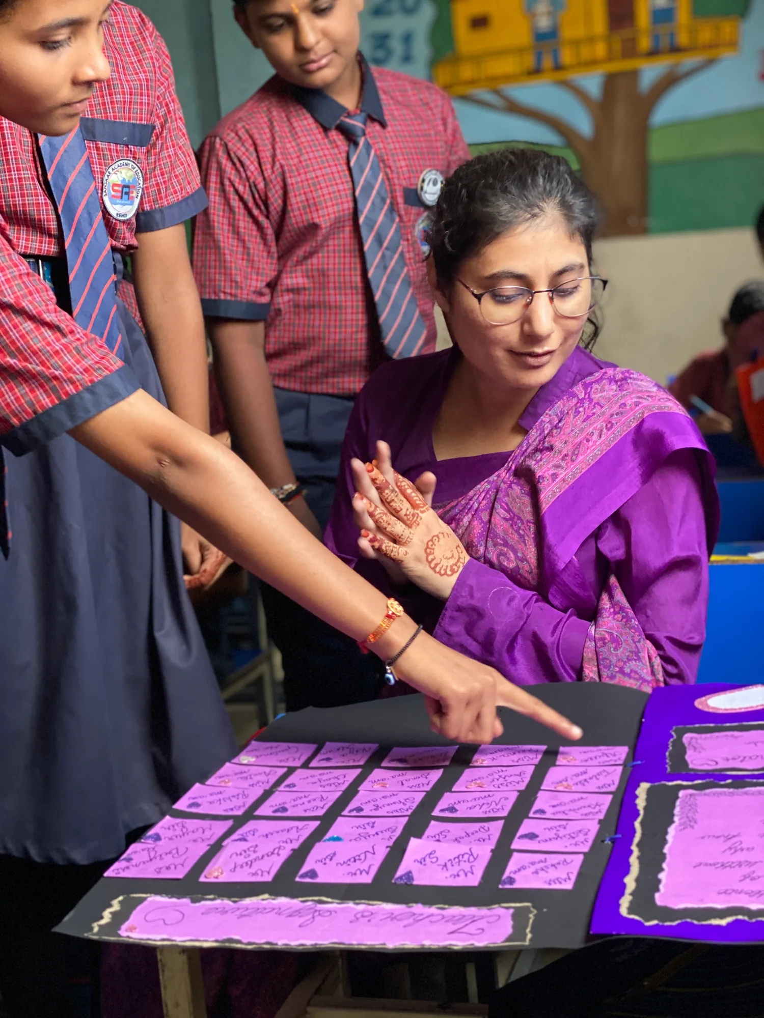 A Sanskar Academy teacher guiding students through a creative project